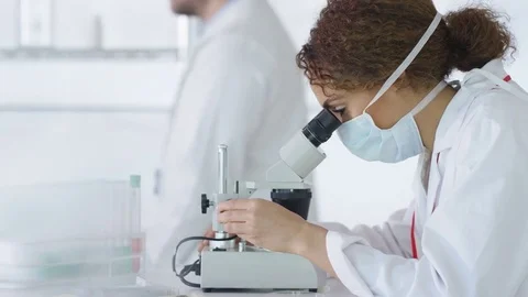 4K Research scientist working in laboratory, looking at sample under microscope. Stock Footage 73306427