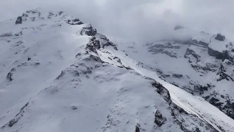 4K reverse aerial drone footage of snowy Aladaglar mountains with fog and snowfa Stock Footage 336449588