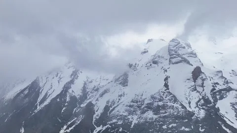 4K reverse aerial drone orbit of snowy Aladaglar mountains with fog and snowfall Stock Footage 336449637