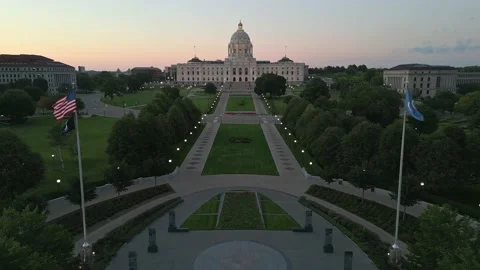 4K Reverse Aerial Shot Of Saint Paul Capitol Between Flags Over WW2 War Memorial Stock Footage 223499049