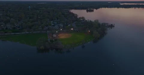 4K Reverse Aerial View of Excelsior Commons Park On Lake Minnetonka At Dusk Stock Footage 247875007