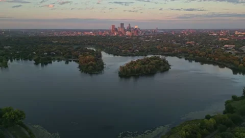 4K Reverse Aerial View of Lake Of The Isles Islands Minneapolis Skyline Sunset Stock Footage 220469528