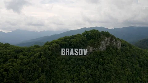 4K Reverse Drone Reveal Brasov Romania Hollywood Sign Romanian Flag Stock Footage