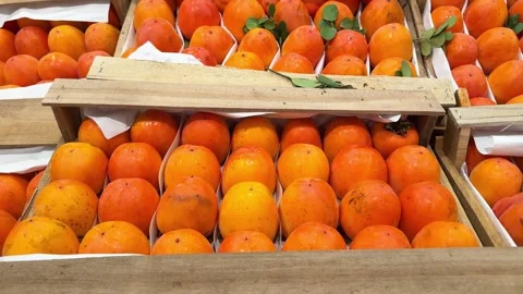 4k, ripe persimmons lie in rows in wooden boxes in a store or market. sale of Stock Footage 293290768