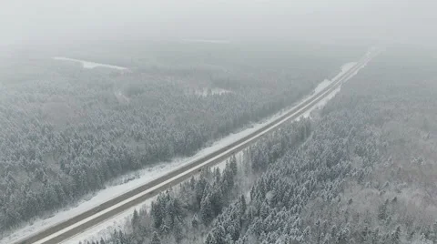 4K. Road in the winter forest with driving cars. Aerial vanishing point. Stock Footage 58973790