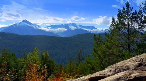 4K Rock Ledge and Trees in Foreground, Mountain Peaks in Background Stock Footage 66757837