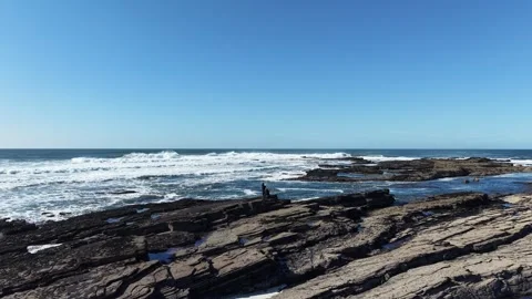 4K Rocky Coastline with Ocean Waves and Person on Shore Vidéo 333704746