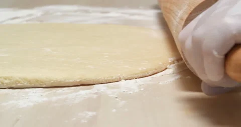 4K - Rolling pin rolls out the Dough Stock Footage 136413393