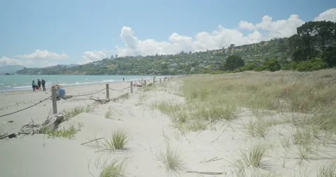 4K - Rolling Sand Dunes Meet Tropical Blue Water - People Enjoying the Sun. Stock Footage 225423970