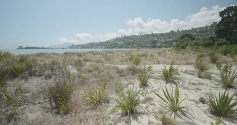 4K - Rolling Sand Dunes Meet Tropical Blue Water - People Enjoying the Sun. Stock Footage 225424874