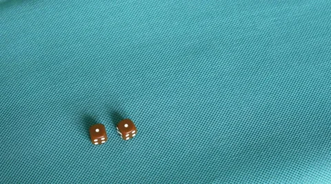 4K rolling snake eyes (a double one) with brown dice on a blue tablecloth Stock Footage 50401436