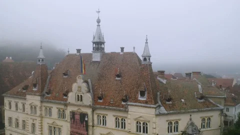 4k Romania Flag Waves on Cold Windy Day Over Sighisoara Aerial View Clock Tower Stock Footage 122461773
