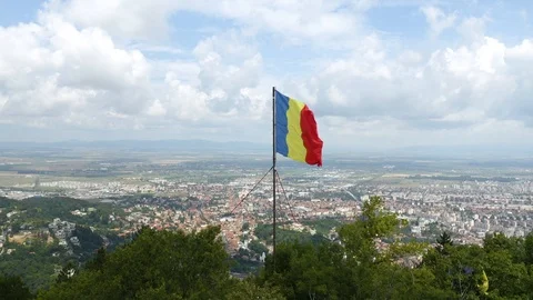 4K Romania Flag Waving in Wind Over Brasov Background Drone Aerial Stock Footage 119374272