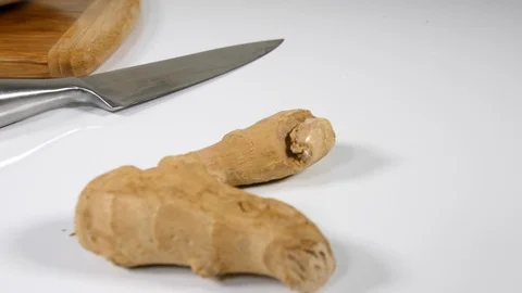 4K root ginger on white surface in kitchen with knife and chopping board Stock Footage 88486363
