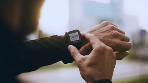 4K Runner starting smart watch timer and running. Man checking heart rate Stock Footage 85103357