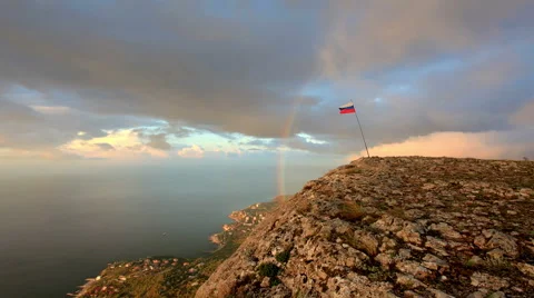 4K. Russian flag on the top of a mountain on the background of the sea  Stock Footage 44403314