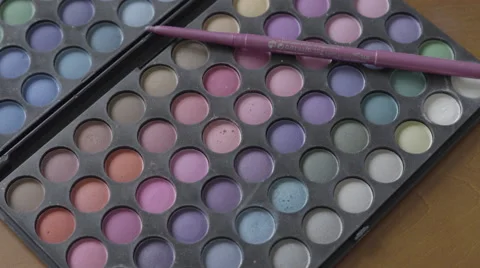 4K S-log 2 eyeliners placed on multicoloured eyeshadow pallet Stock Footage 56526696