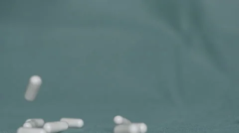 4K S-log 2 pills or drugs fall down from above onto green background Stock Footage 56724789