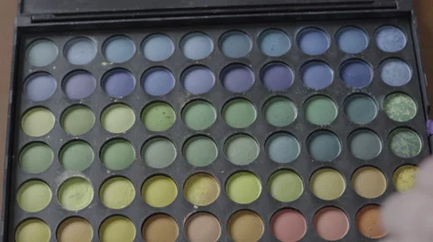 4K S-log 2 testing blues/greens/yellows eyeshadow pallet on caucasian hand Stock Footage 56527675