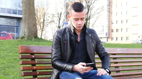 4K Sad man texting in the park Stock Footage 47926971