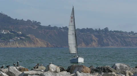 4K Sailboat threading through rough waters in the harbor Stock Footage 40109803