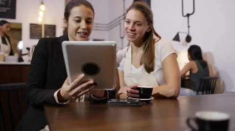 4K Sales rep with computer tablet negotiating a deal with cafe owner Stock Footage 61866599