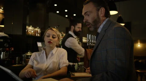4K Salesman with laptop computer discussing a deal with bar owner 库存影片 64915763