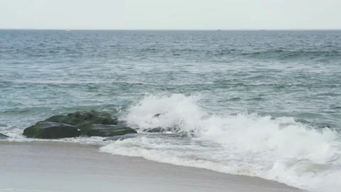 4K. Sandy coast. A big, foaming wave beating against the shore. Stock Footage 130712519