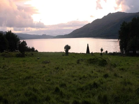 4K Scottish loch surrounded by rolling hills, green grass, as clouds roll across Stock-Footage 80146263