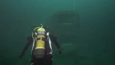4K scuba diver exploring a submerged bus in a quarry 動画素材 188545483