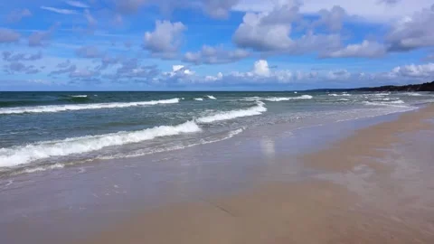 4k seamless loop (1 min) of a beautiful sandy beach with ocean waves crashing Stock Footage 348153364