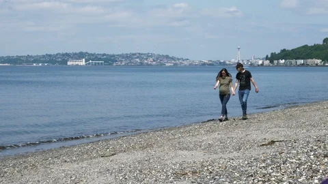 4K Seattle Space Needle Couple Walks Shoreline Towards Camera Video stock 109034775
