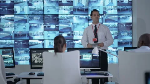 4K Security officer communicating with staff in observation control room Stock Footage