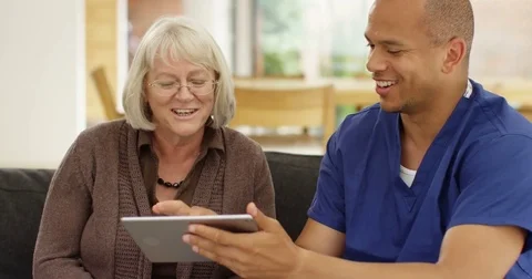 4K Senior lady learning how to use tablet with help from home support nurse Stock Footage 81199292