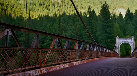 4K Setting Sun on Pine and Fir Forest, Old Steel Cable Bridge in Shadow Stock Footage 67468514