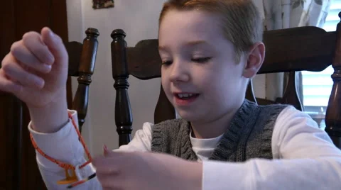 4K - Seven year old boy playing with toy bracelet Stock Footage 46358635