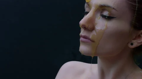 4k shoot of a model in studio with honey pouring on her face Stock Footage 64356655