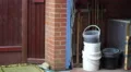 4K Shot of blue garage door closing amidst walled and fenced garden 4k or 4k+ Resolution