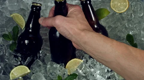 4k Shot of Cold Ice Cubes and Hand Taking Beer Bottle Stock Footage 67461809