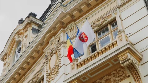 4K shot of Flags of EU Romania and Sibiu on Sibiu Land Credit Bank Stock Footage 114606873