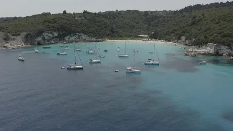 4K shot flying over sailing boats on the turquoise waters of Voutoumi - Dlog Stock Footage 131563428