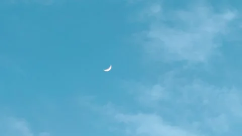 4K shot of half crescent moon against blue sky with clouds during the sunset  Stock Footage 328389781