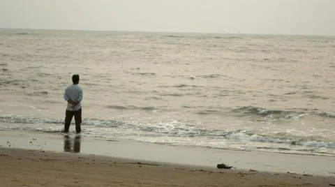 4k Shot of Man Standing in Solitude on Beach in Goa Stock Footage 49317384