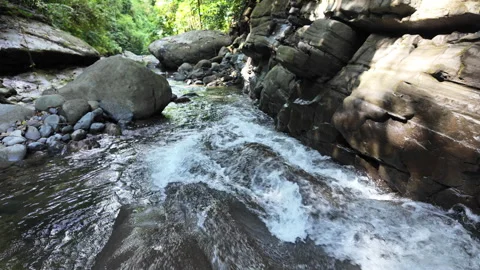 4K Shot Panning Left And Tilting Up Over The Flow Of A Small Rainforest River Stock Footage 285872045