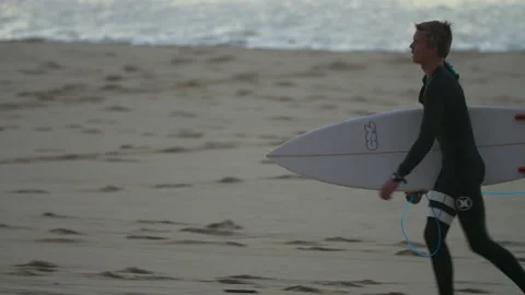 4K shot of professional surfer walking with surfboard on sandy beach near ocean Stock Footage 158633657