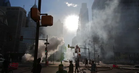 4K SHOT OF SUN SHINING THROUGH BUILDINGS WITH SMOKE COMING UP Stock Footage 131456659