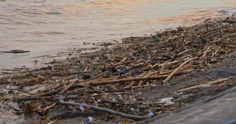 4k shot of sunset beach covered in different types of trash - plastic bottles Stock Footage 114244977