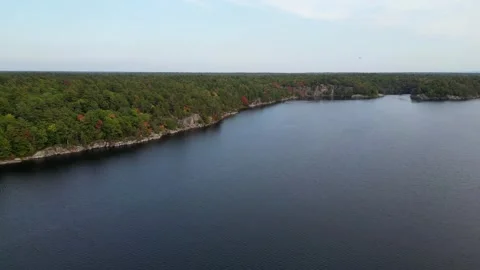 4K Side Flight Over The Clear Water Past The Rocky Shores Of The Lake Stock Footage 256942710