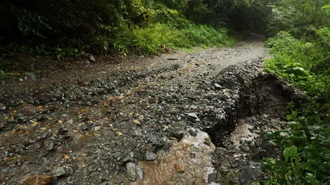 4K. Side view of a forest road destroyed by accumulated water from heavy rain. 動画素材 211338294