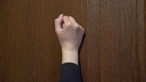 4K. Side view, a woman knocks with her fist o door . Stock Footage 129326289